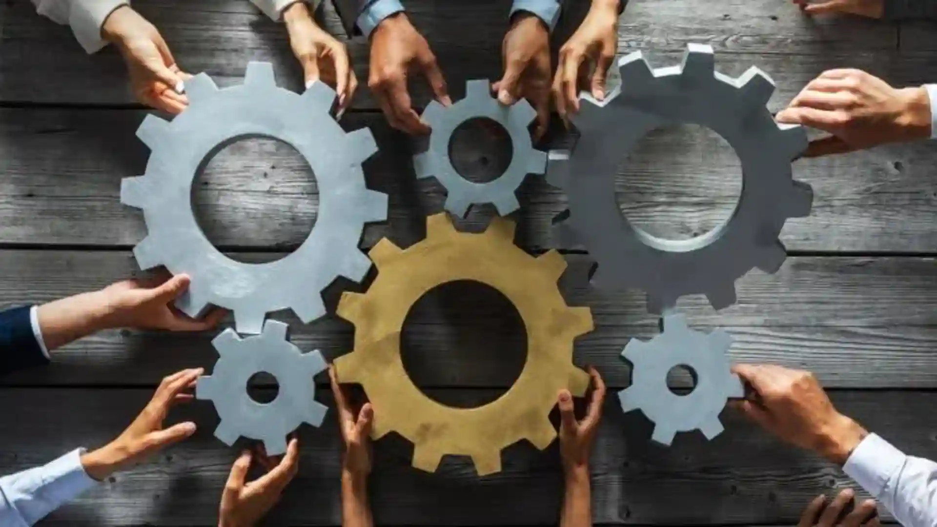 Team members assembling interlocking gears representing collaboration and workforce synergy