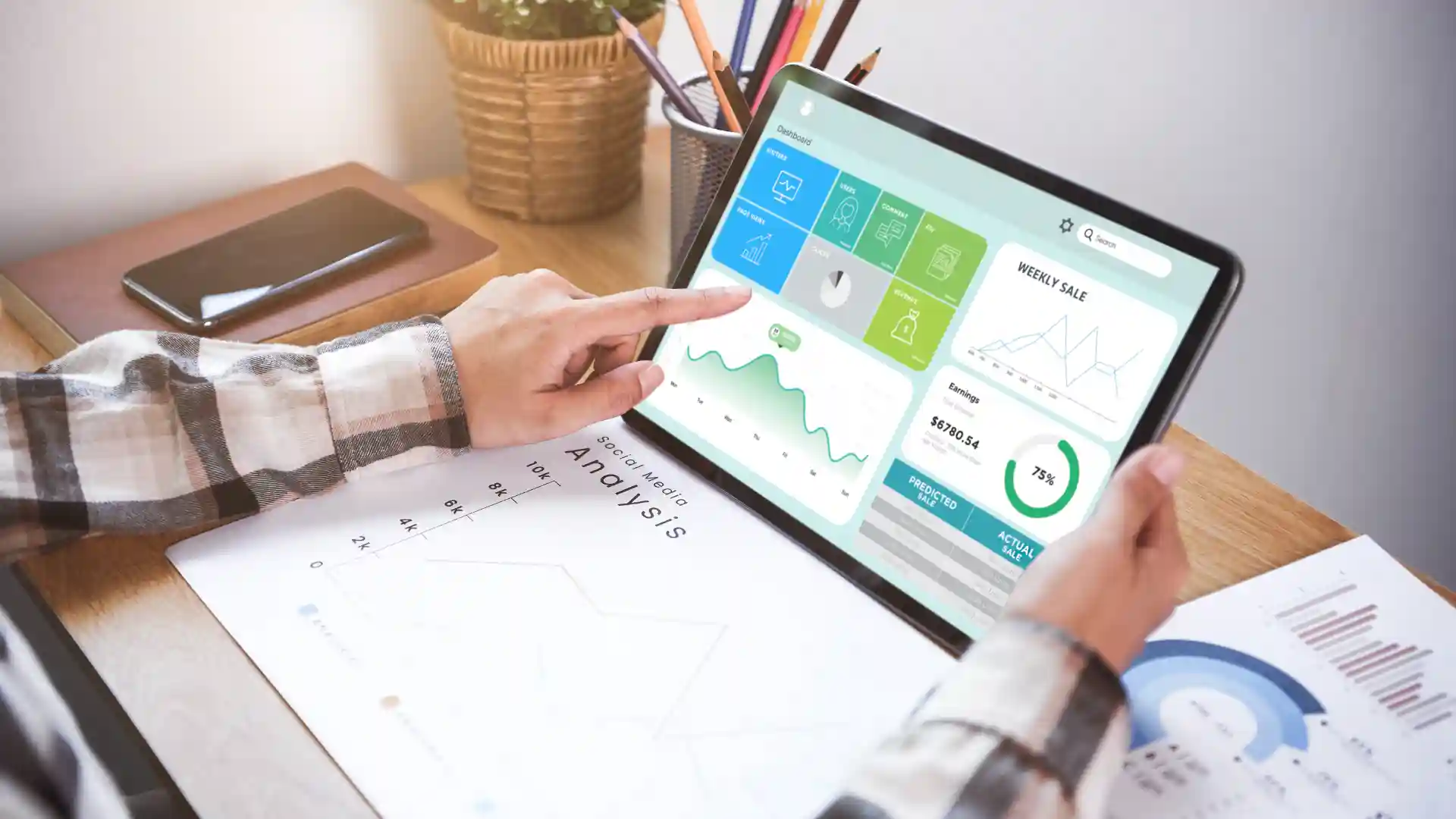 Reviewing digital reports and logistics performance metrics on a tablet with supporting printed charts